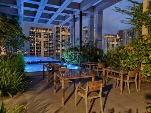 un patio con tavoli e sedie e vista sulla città di FREE Parking Revo 2Room Rooftop Pool L21 a Kuala Lumpur