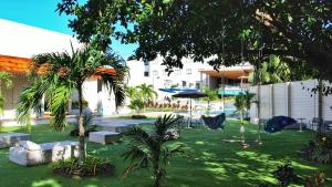 a courtyard with benches and palm trees and a building at Dreamer Beach Club in San Andrés