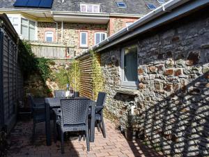 a patio with chairs and a table and a building at Old Skittle Alley in High Bickington