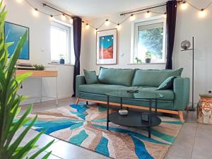 uma sala de estar com um sofá verde e uma mesa em Apartment close to Science Park em Blaustein