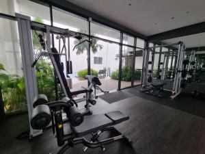 una palestra con diverse macchine per il battistrada in una stanza con finestre di FREE Parking Revo 2Room Rooftop Pool L21 a Kuala Lumpur