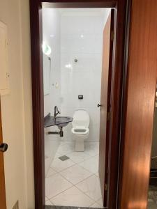 a bathroom with a toilet and a sink at Casa espaçosa para lazer em família in Águas de São Pedro