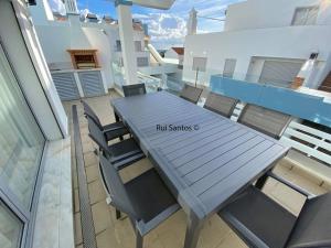 una mesa y sillas en un balcón con un cartel. en Manta Villa 2, en Manta Rota