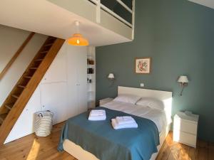 ein Schlafzimmer mit einem Bett und einer Treppe in der Unterkunft Villa Paulownia - à 1,2km des plages - tout confort au coeur du bourg in Jard-sur-Mer