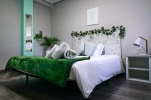 a bedroom with a large bed with a green cover at Bioparco Apartment in Valencia