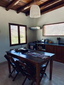 a kitchen with a wooden table and a stove at La Nochera in Tilcara