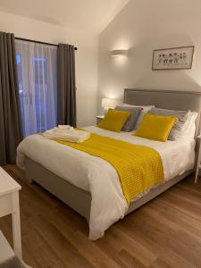 プリマスにあるRural Retreat in Devonのベッドルーム1室(大型ベッド1台、黄色い枕付)