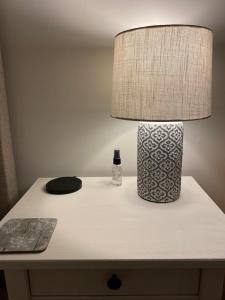 a table with a lamp and a bottle of water on it at Rural Retreat in Devon in Plymouth