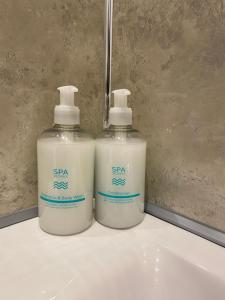 two bottles of soap sitting on top of a sink at Rural Retreat in Devon in Plymouth