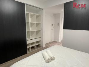 1 dormitorio con cama blanca y pared negra en Rent Muñiz en Buenos Aires