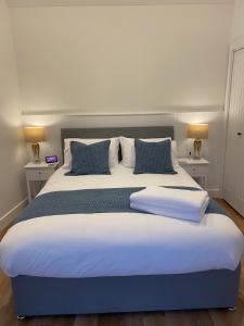 Cama grande con sábanas y almohadas azules y blancas en Rural Retreat in Devon en Plymouth