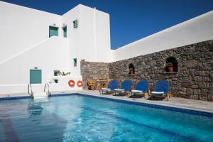 a villa with a swimming pool and blue chairs at Ornos Apartments in Ornos