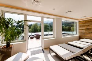 a room with windows and chairs and a balcony at R&R Residenzen Ferienwohnungen in Mitterbach
