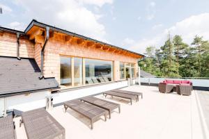 a patio with benches and tables on a building at R&R Residenzen Ferienwohnungen in Mitterbach