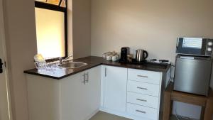 a small kitchen with a sink and a microwave at King Suite in Hilton