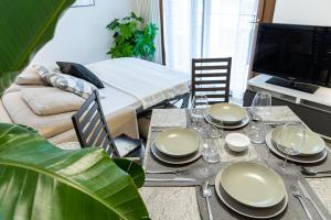 stół jadalny z talerzami i okularami w obiekcie [CANTU-COMO] WiFi, Design & Relax w mieście Cantù