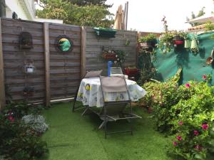 a garden with a table and some flowers and a fence at Appartement à l’étage indépendant in Ars-en-Ré +6 photos