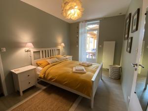 1 dormitorio con cama y lámpara de araña en Villa Paulownia - à 1,2km des plages - tout confort au coeur du bourg en Jard-sur-Mer