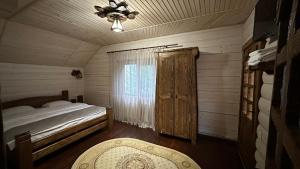 a bedroom with a bed and a window and a chair at Forest House in Migovo