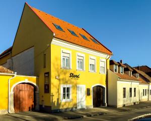 un edificio amarillo con techo naranja en una calle en Flóra Lak en Sopron