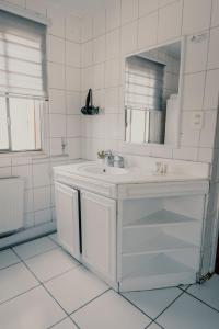 Baño blanco con lavabo y espejo en Mondrian Santiago, en Santiago