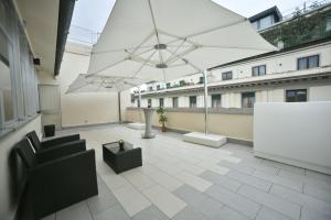 a balcony with a large white umbrella on a building at Garden Blue in Florence