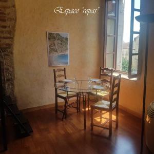 uma sala de jantar com uma mesa de vidro e cadeiras em Semi-duplex Ancien Hôtel Particulier em Bourg-en-Bresse