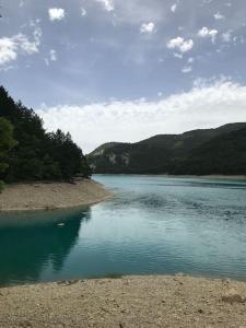 une grande étendue d'eau avec des montagnes en arrière-plan dans l'établissement La maison des Pins, à Saint-Julien-du-Verdon