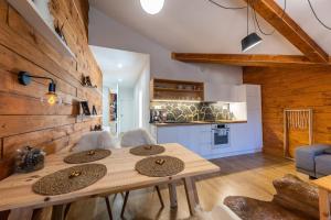 - une cuisine et une salle à manger avec une table et des chaises dans l'établissement Lúčnica apartments Tále, à Tale