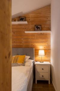 a bedroom with a bed and a night stand with a lamp at Lúčnica apartments Tále in Tale