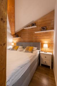 a bedroom with a large bed with wooden walls at Lúčnica apartments Tále in Tale