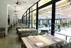 a row of tables in a restaurant with windows at Ohtels Les Oliveres in Perelló