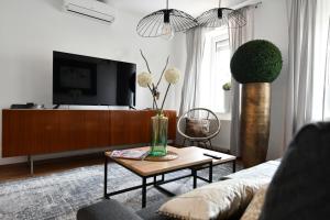 een woonkamer met een tv en een salontafel bij Heimat Floral Ferienhaus in Wadgassen