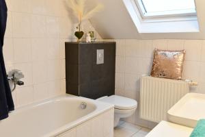 a bathroom with a tub and a toilet and a sink at Heimat Floral Ferienhaus in Wadgassen +22 photos