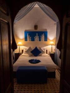 a bedroom with a white bed with a blue canopy at Riad Casa Lalla in Marrakech
