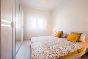 Dormitorio blanco con cama con almohadas amarillas en Apartment dream view, en Krilo