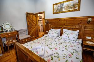 1 dormitorio con cama, mesa y espejo en Къща за гости Плевнята, en Bansko