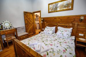 a bedroom with a bed and a table and a mirror at Къща за гости Плевнята in Bansko