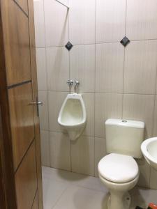 een badkamer met een toilet, een urinoir en een wastafel bij Monoambiente en Ciudad del Este - Py in Ciudad del Este