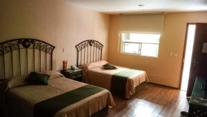 ein Hotelzimmer mit 2 Betten und einem Fenster in der Unterkunft HOTEL PLAZA PACHUCA in Zapotlán de Juárez