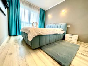 Un dormitorio con una cama en una habitación con cortinas azules. en Green Forest View, en Timisoara