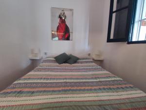 - une chambre avec un lit et une couverture colorée dans l'établissement Casa Portal, à El Palmar