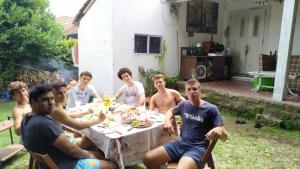 un grupo de hombres sentados alrededor de una mesa comiendo en @ElChalet_PlayaGrande en insta. disfruta del mejor ambiente en el mejor barrio. Habitaciones cerrada por grupo de amigos con baño privado. en Mar del Plata