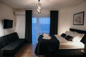 sypialnia z łóżkiem, kanapą i oknem w obiekcie Studio apartman Mia w mieście Županja