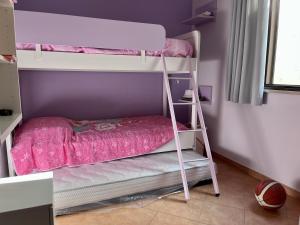 a bedroom with a bunk bed with a ladder at Casa EleGiò - Blue Village 2 in Marina di Pisticci