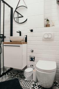 a bathroom with a white toilet and a sink at Studio apartman Mia in Županja