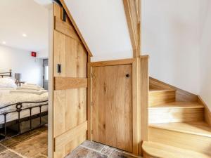 Una puerta de madera en un dormitorio con cama en Piggledy Cross Barn, en Butterton