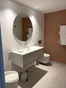 een badkamer met een wastafel, een toilet en een spiegel bij Soldeu appartement lumineux en face des piste ski HUT08245 in Canillo