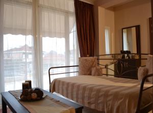 a bedroom with a bed and a table and a window at Harmony in Tríkala