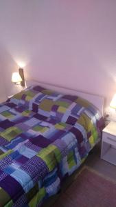 Una cama con un edredón colorido en un dormitorio en Lomas de Cerro Piriapolis Rincon y Zufrategui, en Piriápolis